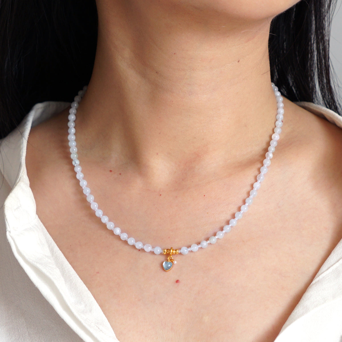 Natural Aquamarine beaded heart pendant choker necklace worn on model neck with white shirt
