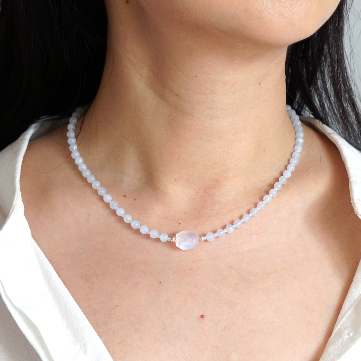 Natural light blue Aquamarine and iridescent Rainbow Moonstone beaded choker necklace worn on model neck
