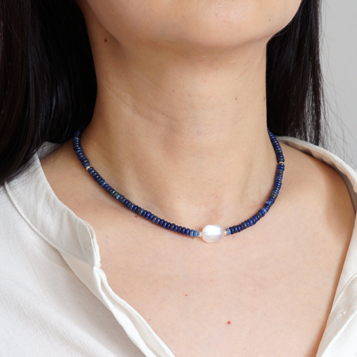 Natural Lapis Lazuli and Moonstone beaded choker necklace worn on model neck with white shirt
