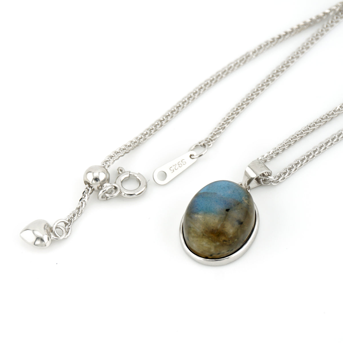 A sterling silver necklace featuring an oval labradorite pendant with natural blue, brown, and gold marbling, displayed alongside its silver clasp and heart charm on a white background.