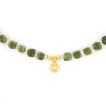 Close up detail of 18k gold plated S925 silver CZ sunburst charm on natural cut Southern Jade beads
