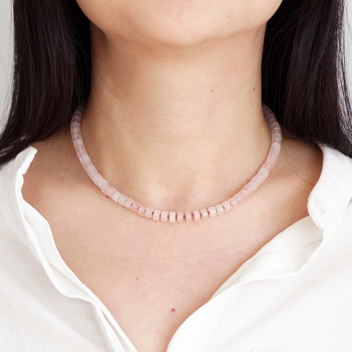 Natural Rose Quartz disc beads choker necklace worn on model neck with white shirt
