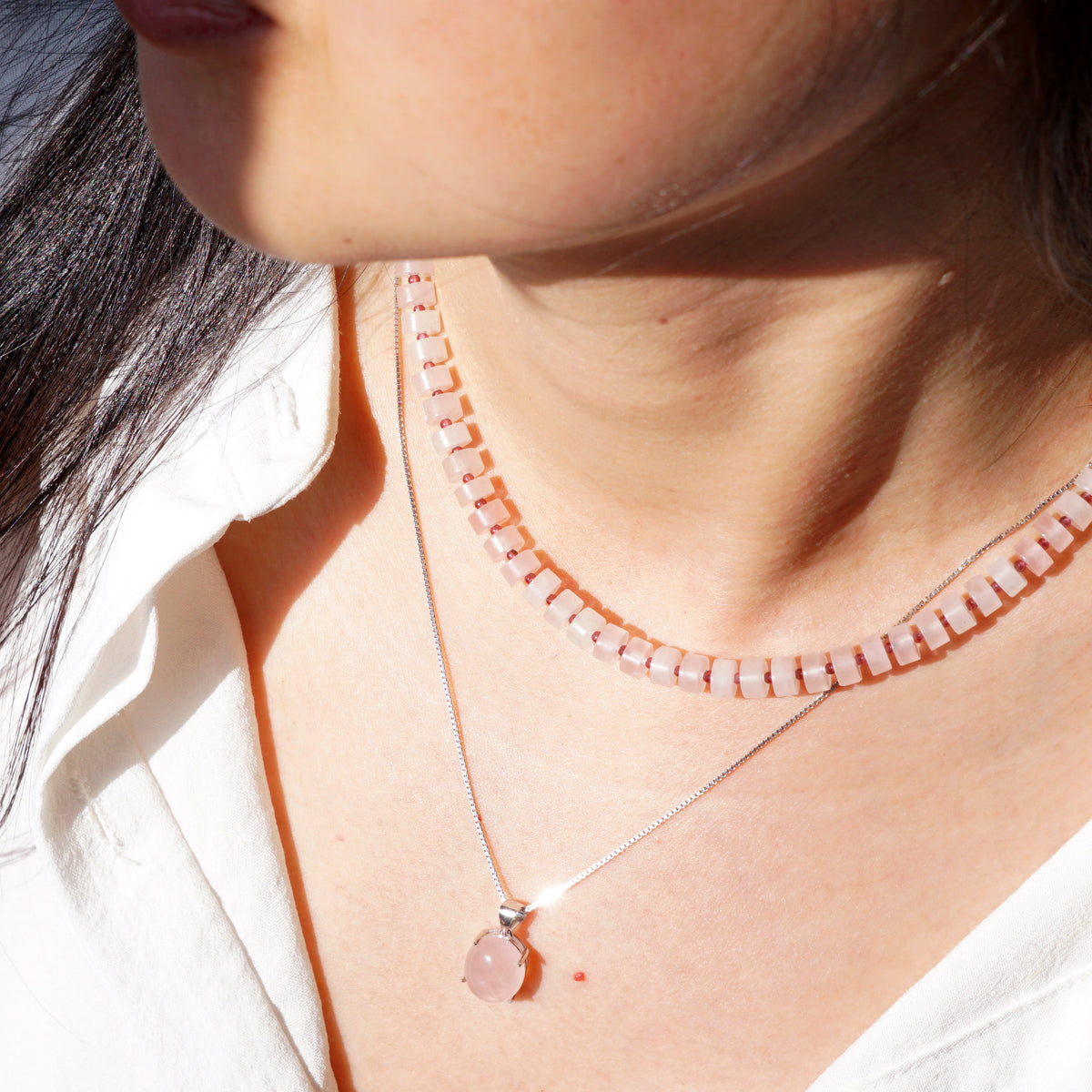 Layered natural Rose Quartz disc choker and oval Rose Quartz pendant silver necklace set on model
