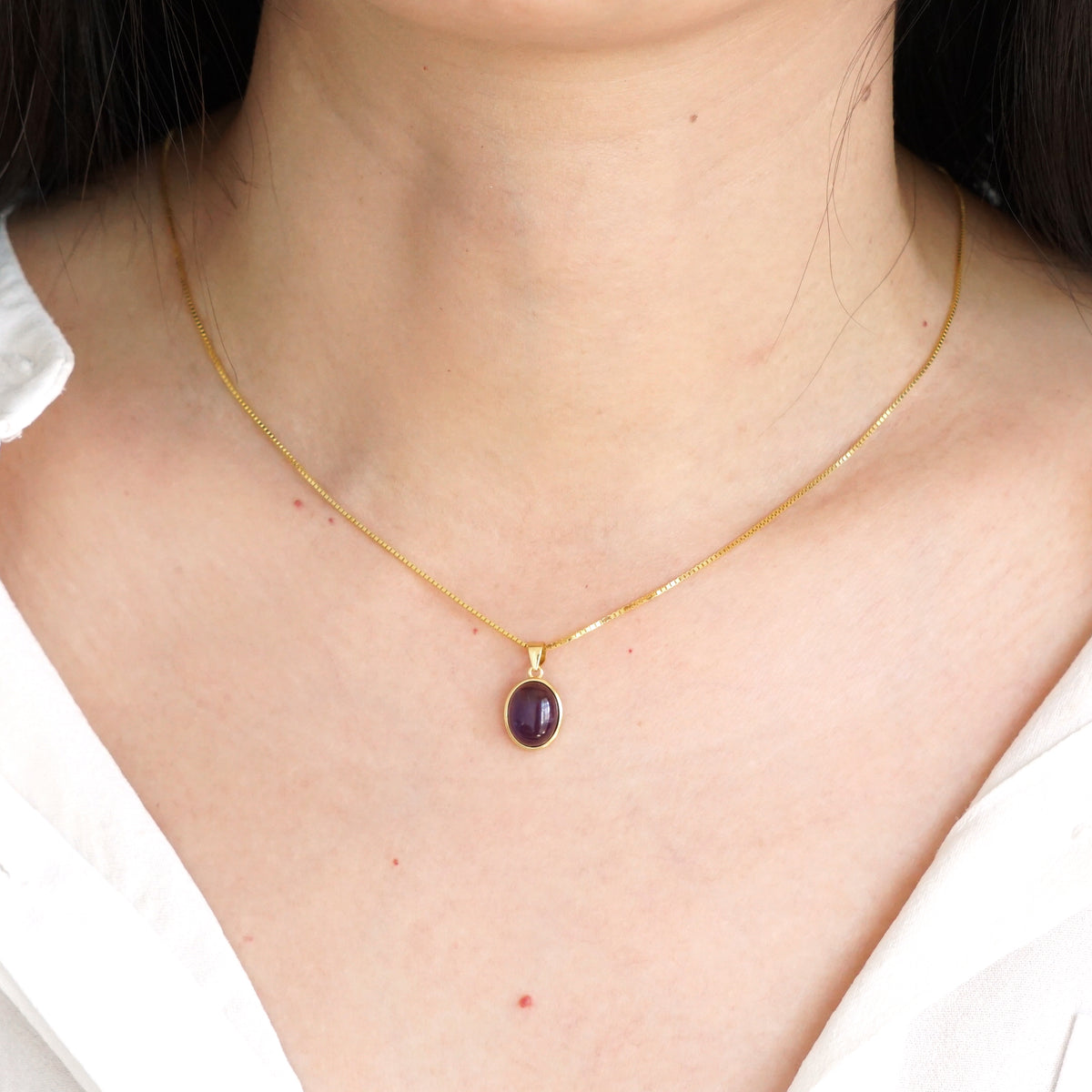 Everyday minimalist natural Amethyst oval pendant necklace styled with white shirt on model
