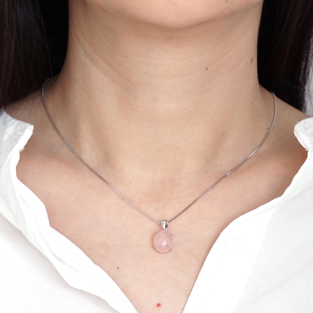 Natural soft pink Rose Quartz pendant silver necklace worn on model neck with white shirt

