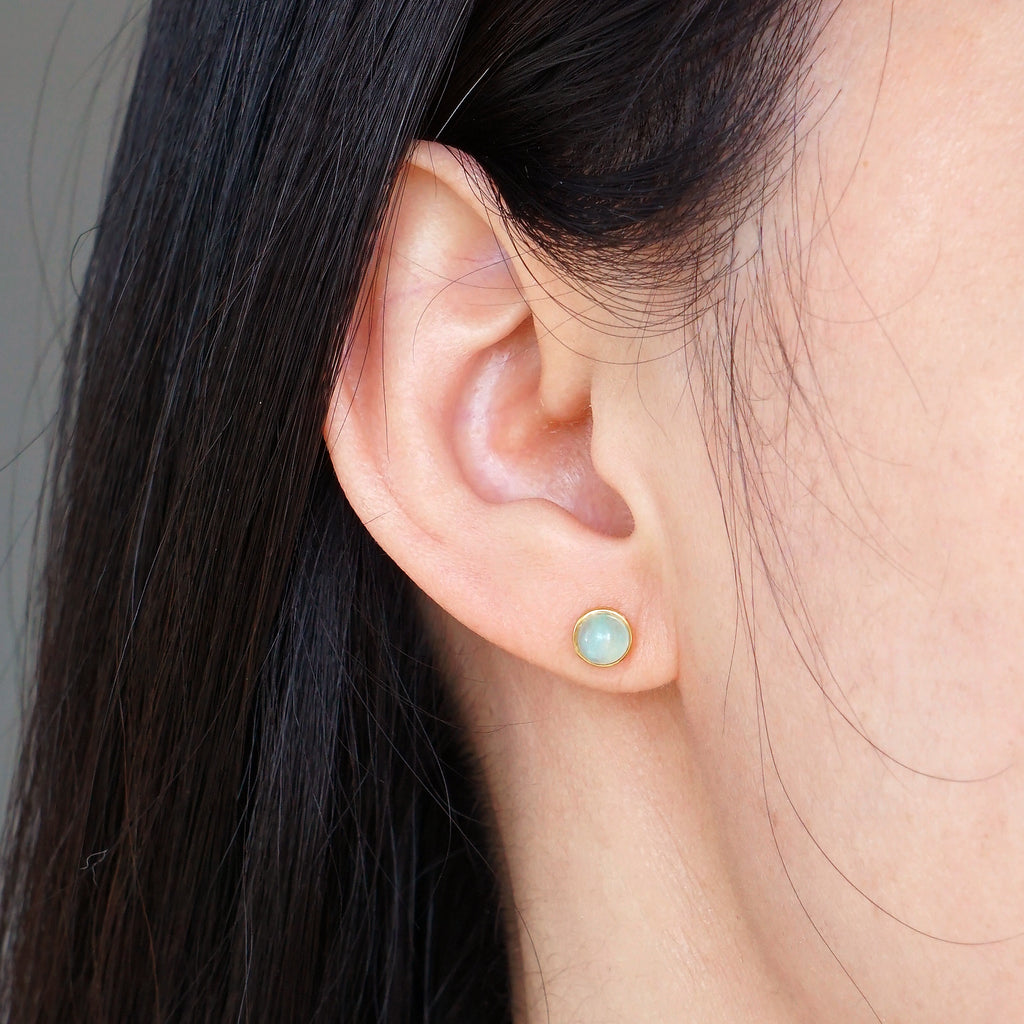 Natural light blue Aquamarine gold bezel stud earring worn on model ear
