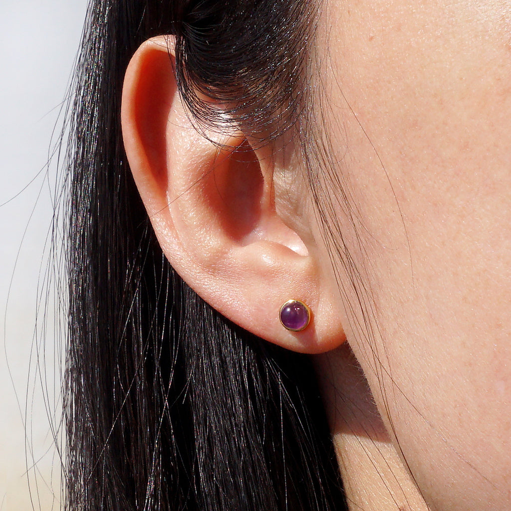 Natural Amethyst gold bezel stud earrings worn on ear for everyday minimalist look

